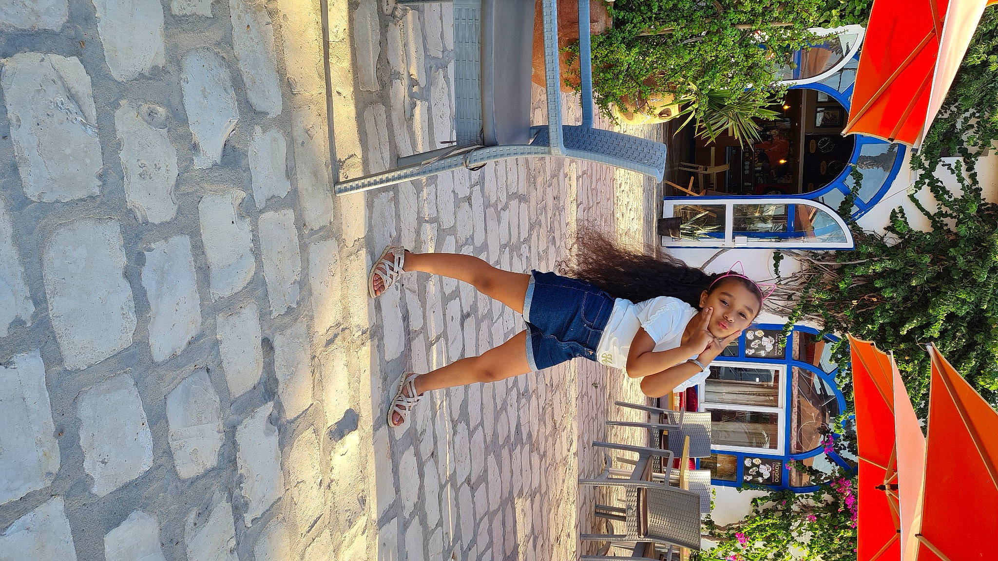 Mayssam participe au concours pour gagner de l'argent avec cette photo : azure, building, chair, electric_blue, facade, flag, fun, human_leg, leisure, person, plant, road, shorts, street, street_fashion, t_shirt, thigh, travel, tree, vacation