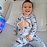 bed, bedroom, blue, child, face, hair_style, happy, healthcare, hospital_bed, indoor, medical_tape, onesie, pajamas, patient, pillow, playful, smiling, tongue_out, toy, young_child