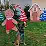 dog, german_shepherd, grass, leaves, autumn, holiday_decorations, gingerbread_figure, gingerbread_house, candy_cane, christmas_trees, outdoor, daylight, building, greenery, festive, decoration, park, seasonal, smiling_figure, pet