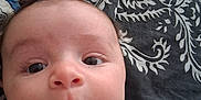 Lao a rejoint le concours — aidez-le/la à gagner de superbes lots ! animal_print, baby, child, closeup, curious, expression, eyes, face, grey_shirt, hair, head, indoors, infant, lying_down, mouth, nose, patterned_blanket, portrait, skin, young_child
