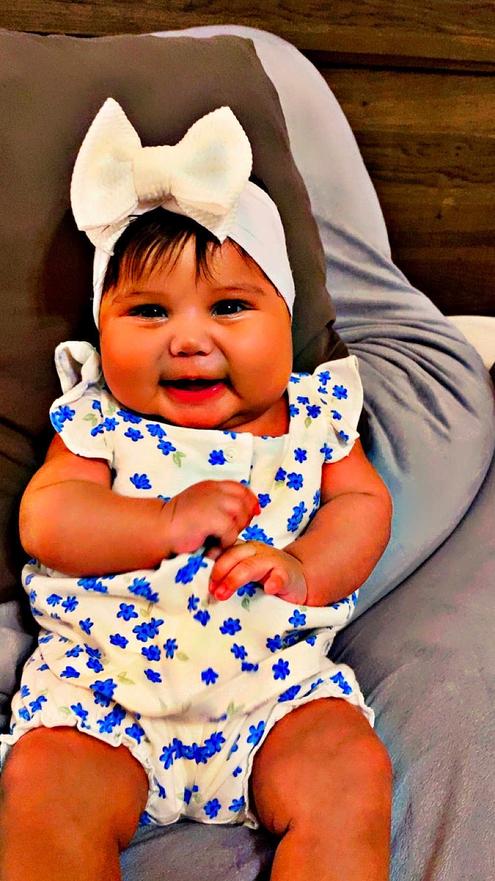 Mya Aylany joined the competition — help win amazing prizes! baby, child, smiling, headband, bow, floral_outfit, blue_flowers, cushion, gray, sitting, cute, happy, indoors, portrait, chubby_cheeks, infant, clothing, person, cute_outfit, headwear