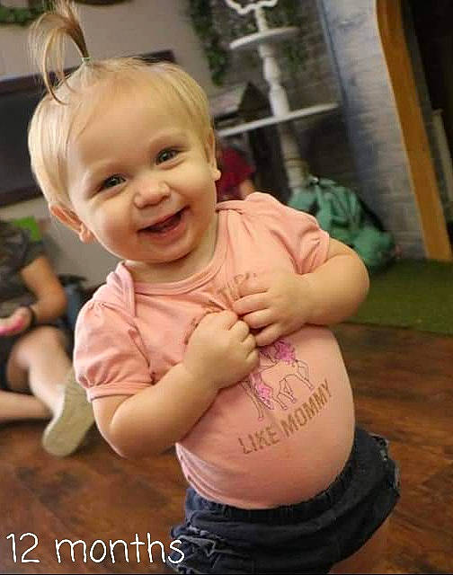 Lilly joined the competition — help win amazing prizes! abdomen, baby, baby_toddler_clothing, cheek, facial_expression, gesture, hair, happy, head, human_body, interaction, joy, mouth, person, pink, skin, smile, stomach, thigh, thumb