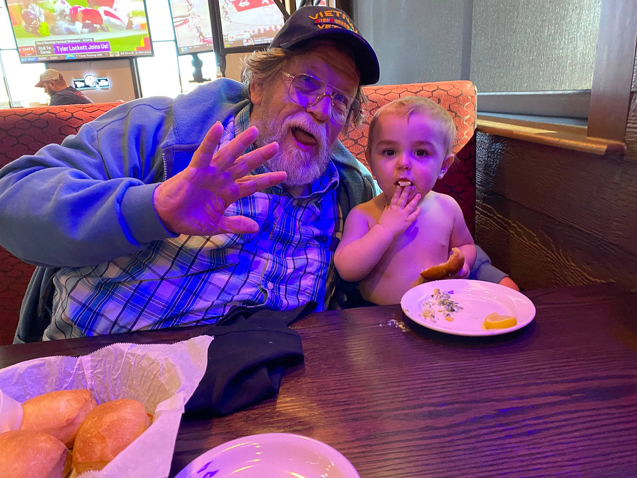 Björn is registered to the contest to win money with this photo: baseball_cap, cap, chair, child, cuisine, dish, dishware, event, food, fun, hat, headwear, person, picture_frame, plate, purple, serveware, sharing, sun_hat, table