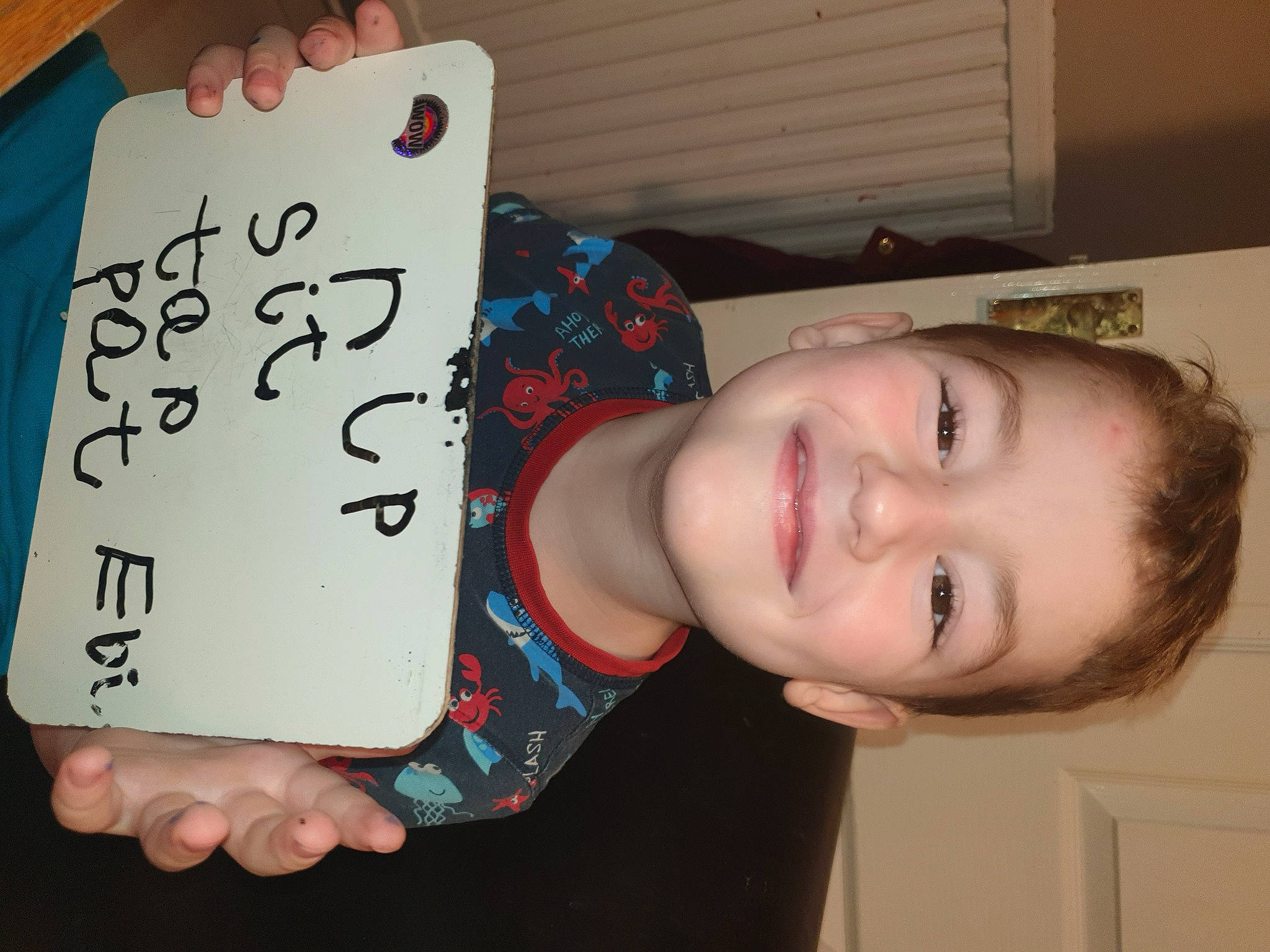 Edward is registered to the contest to win money with this photo: chest, child, elbow, eye, eyelash, facial_expression, finger, font, hairstyle, handwriting, happy, joy, nail, number, pattern, person, room, smile, thumb, toddler