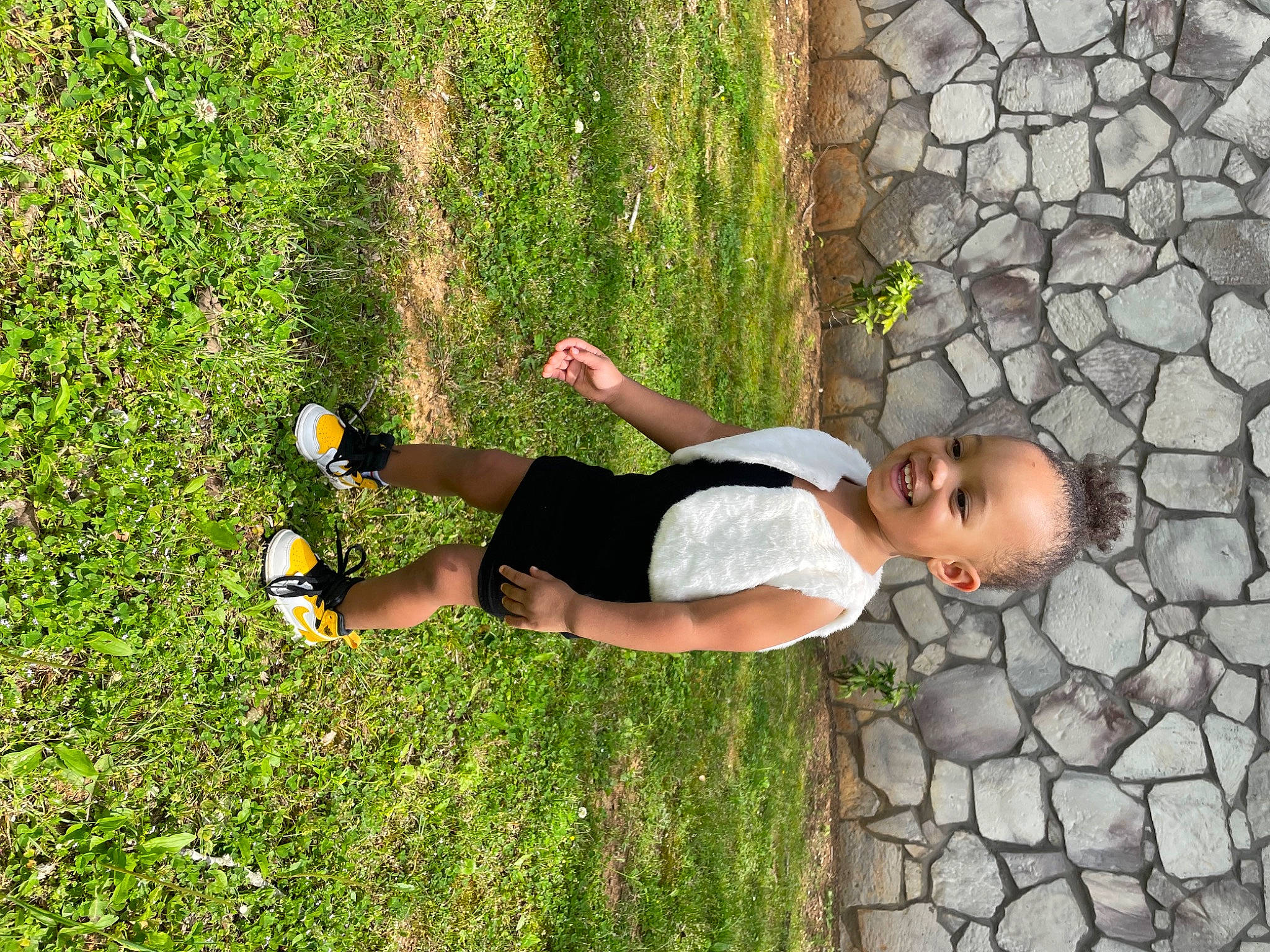 Avianna is registered to the contest to win money with this photo: ball, cobblestone, elbow, fun, garden, grass, happy, human_leg, joy, knee, leaf, leisure, people_in_nature, person, plant, recreation, shadow, shorts, shrub, sitting