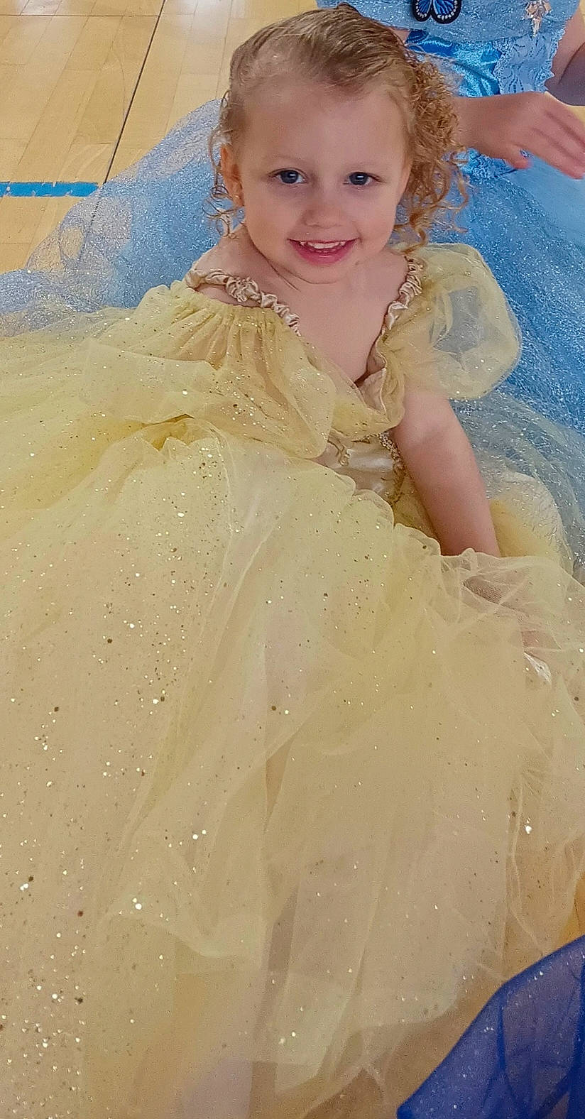 Lya participe au concours pour gagner de l'argent avec cette photo : blue, bridal_accessory, bridal_clothing, dress, embellishment, event, face, fashion_design, flash_photography, formal_wear, gown, happy, headpiece, joy, long_hair, peach, person, sleeve, smile, toddler