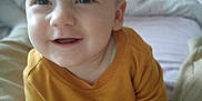 Matthew participe au concours pour gagner de l'argent avec cette photo : baby, bed, blanket, child, closeup, cozy, cute, eyes, face, hands, happy, indoor, legs, mustard_color, person, portrait, smiling, soft_light, sweater, young_child