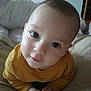 baby, child, closeup, curious, cushions, cute, eyes, face, hands, head, indoor, infant, mustard_yellow, person, portrait, skin, smile, soft_furniture, sweater, young