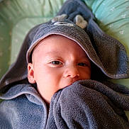 Matthew participe au concours pour gagner de l'argent avec cette photo : baby, towel, hooded_towel, face, eyes, blanket, bedspread, infant, soft_texture, curious, child, wrapped, cozy, indoor, closeup, young_child, cute, comfort, nibble, resting