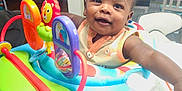 Elijah joined the competition — help win amazing prizes! baby, chair, child, closeup, colorful, curious, face, furniture, happy, home, indoor, infant, light, person, playtime, smiling, table, toy, walker, window