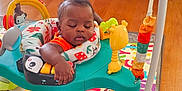 Elijah joined the competition — help win amazing prizes! activity_jumper, alphabet, baby, child, colorful, cute, fireplace, foot, furniture, hand, home, indoor, infant, orange_clothing, playmat, relaxed, sleeping, stone_wall, toy, wood_floor