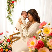 Luis joined the competition — help win amazing prizes! baby, woman, mother, infant, flowers, floral_arrangement, bench, knitwear, glasses, portrait, indoor, love, family, holding, peaceful, decor, warm_colors, seated, tenderness, cute