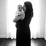 Luis joined the competition — help win amazing prizes! baby, woman, child, holding, black_and_white, portrait, indoor, curtains, window, floor, glasses, dress, person, love, family, mother, infant, backlit, home, tender