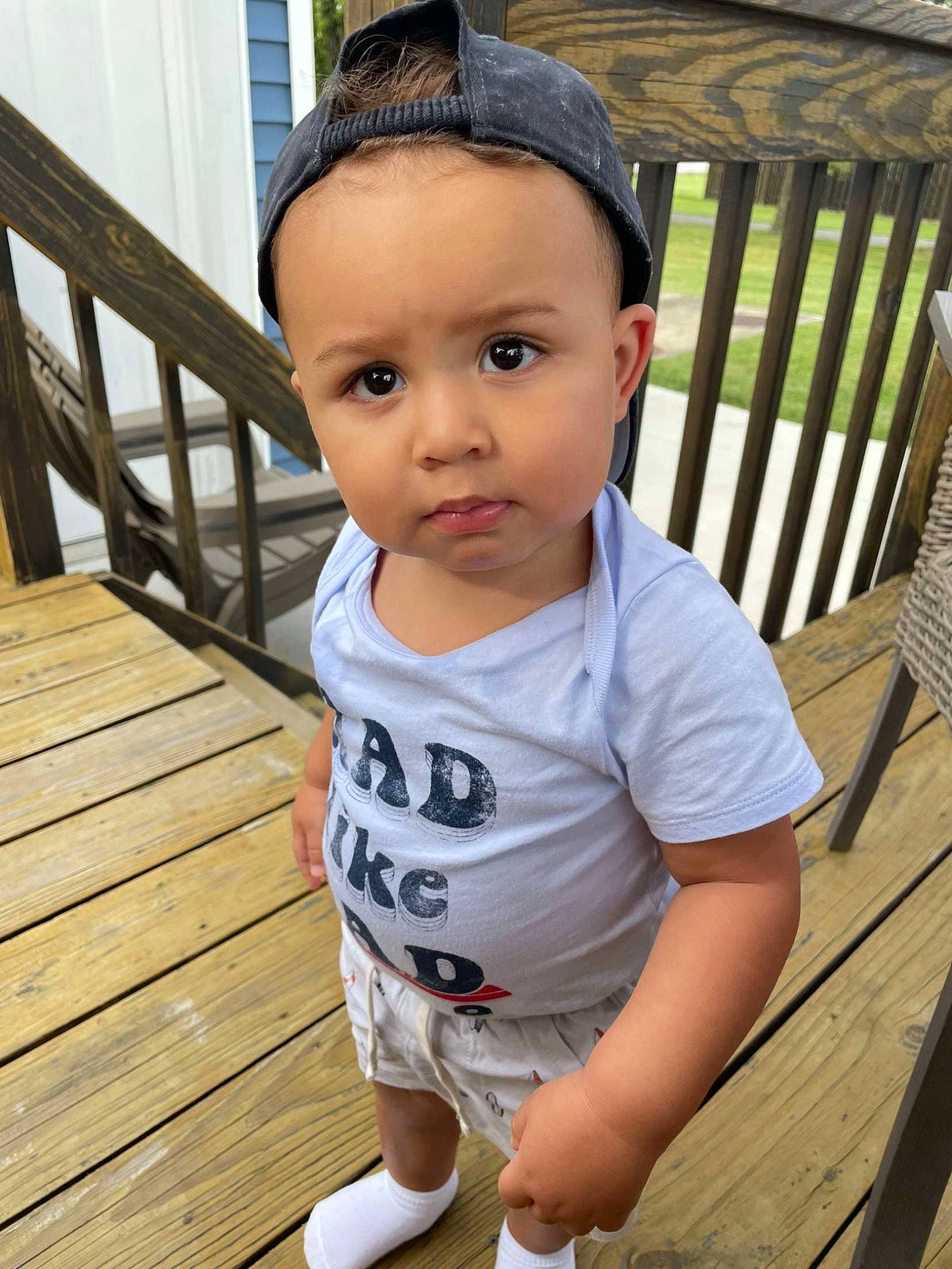 Izaiah is registered to the contest to win money with this photo: baby_toddler_clothing, black, cheek, child, eye, face, grass, happy, hat, leisure, outdoor_furniture, person, porch, product, sitting, skin, sleeve, summer, t_shirt, toddler