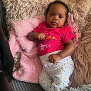 Aryiah is registered to the contest to win money with this photo: baby, infant, child, couch, pillow, blanket, pink, polka_dot, clothing, face, portrait, indoor, relaxing, cozy, furniture, cute, person, resting, smiling, home