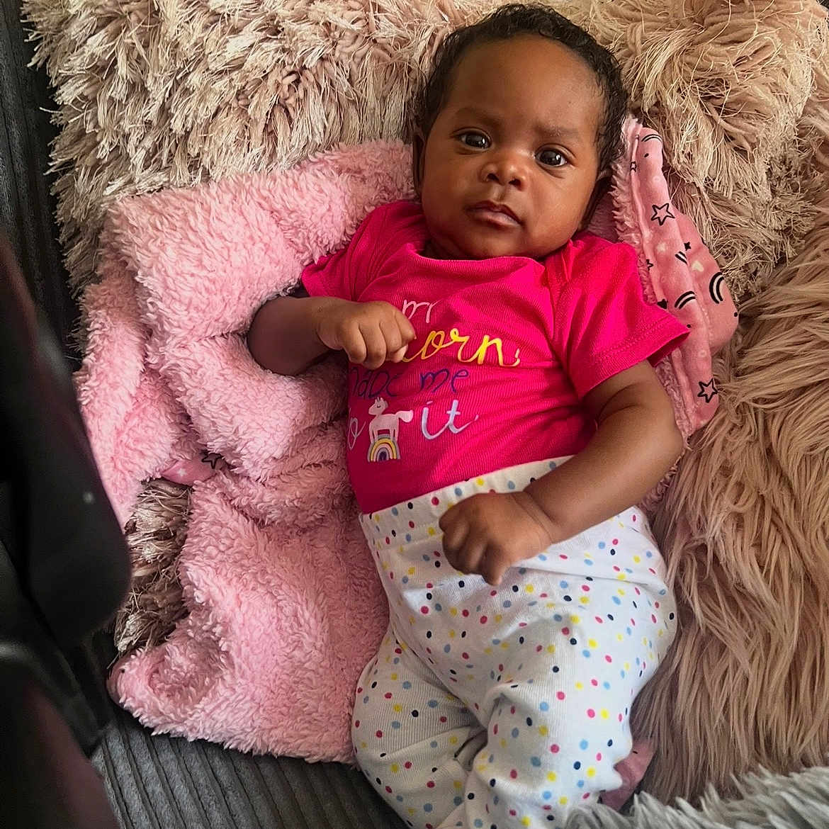 Aryiah is registered to the contest to win money with this photo: baby, infant, child, couch, pillow, blanket, pink, polka_dot, clothing, face, portrait, indoor, relaxing, cozy, furniture, cute, person, resting, smiling, home