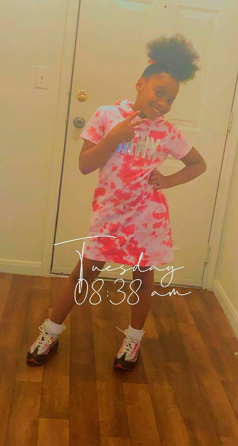 Shaniya is registered to the contest to win money with this photo: door, floor, flooring, footwear, happy, hardwood, human_leg, joy, knee, leg, neck, pattern, person, shoe, shoulder, sleeve, sneakers, sock, t_shirt, thigh