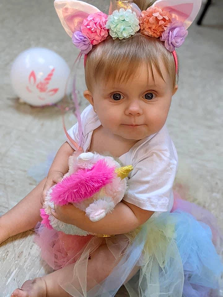 Aleia is registered to the contest to win money with this photo: baby, baby_toddler_clothing, beauty, child, face, hair_accessory, hairstyle, happy, headband, headgear, headpiece, magenta, person, petal, pink, skin, sleeve, smile, thigh, toddler