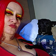 Smokey is registered to the contest to win money with this photo: black_dog, casual, chain_necklace, closeup, colorful, couch, dog, expression, fashion, hoodie, indoor, makeup, person, pet, pillow, portrait, red_eyeshadow, red_hair, small_dog, yellow_eyeshadow