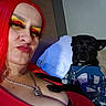 black_dog, casual, chain_necklace, closeup, colorful, couch, dog, expression, fashion, hoodie, indoor, makeup, person, pet, pillow, portrait, red_eyeshadow, red_hair, small_dog, yellow_eyeshadow