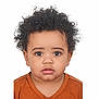 baby, brown_shirt, casual_clothing, child, close_up, curly_hair, cute, expression, face, headshot, indoors, innocent, looking_at_camera, natural_light, person, portrait, studio, toddler, white_background, young_child