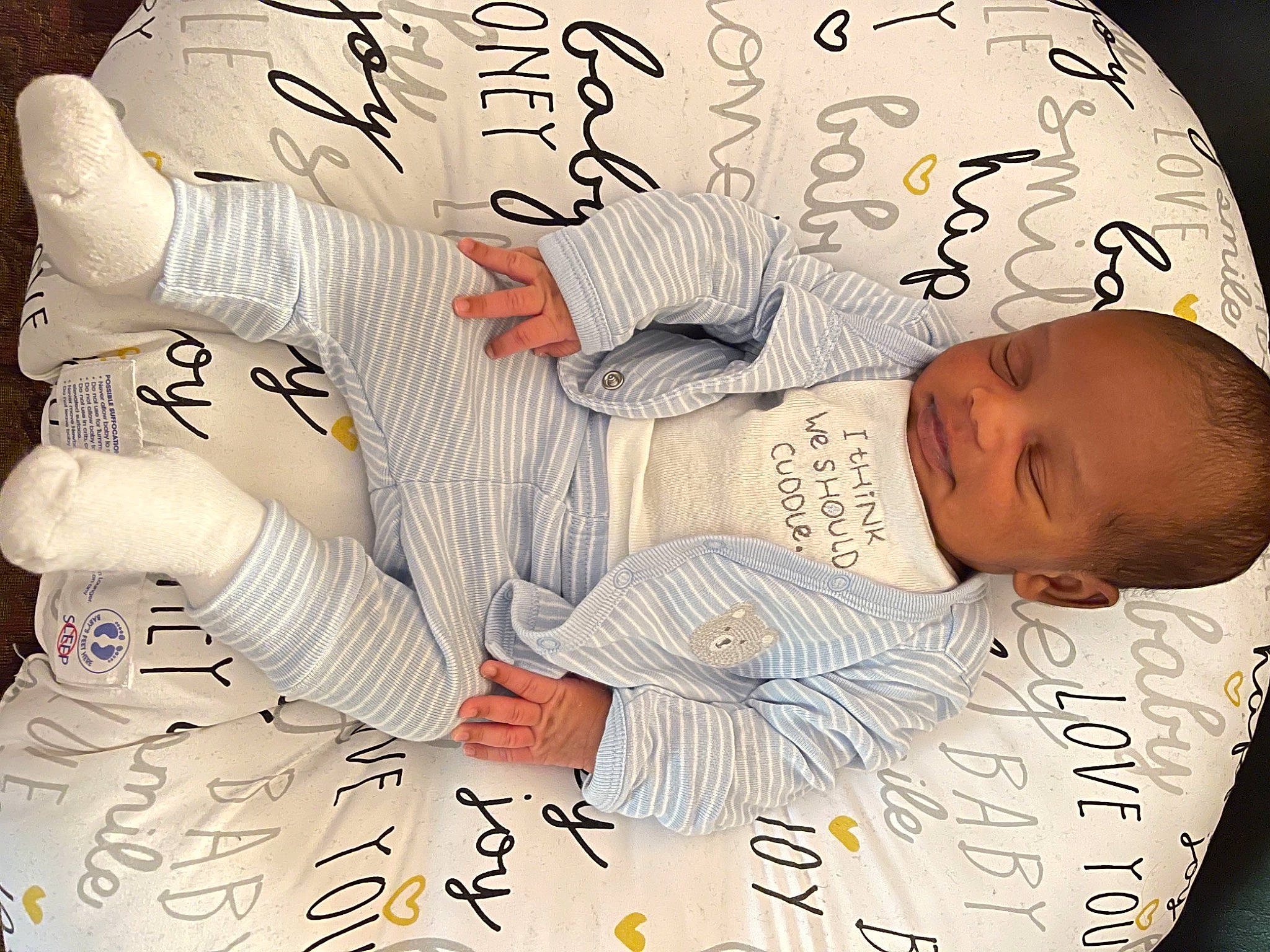 Dominique is registered to the contest to win money with this photo: baby, baby_sleeping, bedtime, child, comfort, design, finger, font, gesture, hand, happy, illustration, linens, nap, paper, pattern, person, sleeve, t_shirt, textile