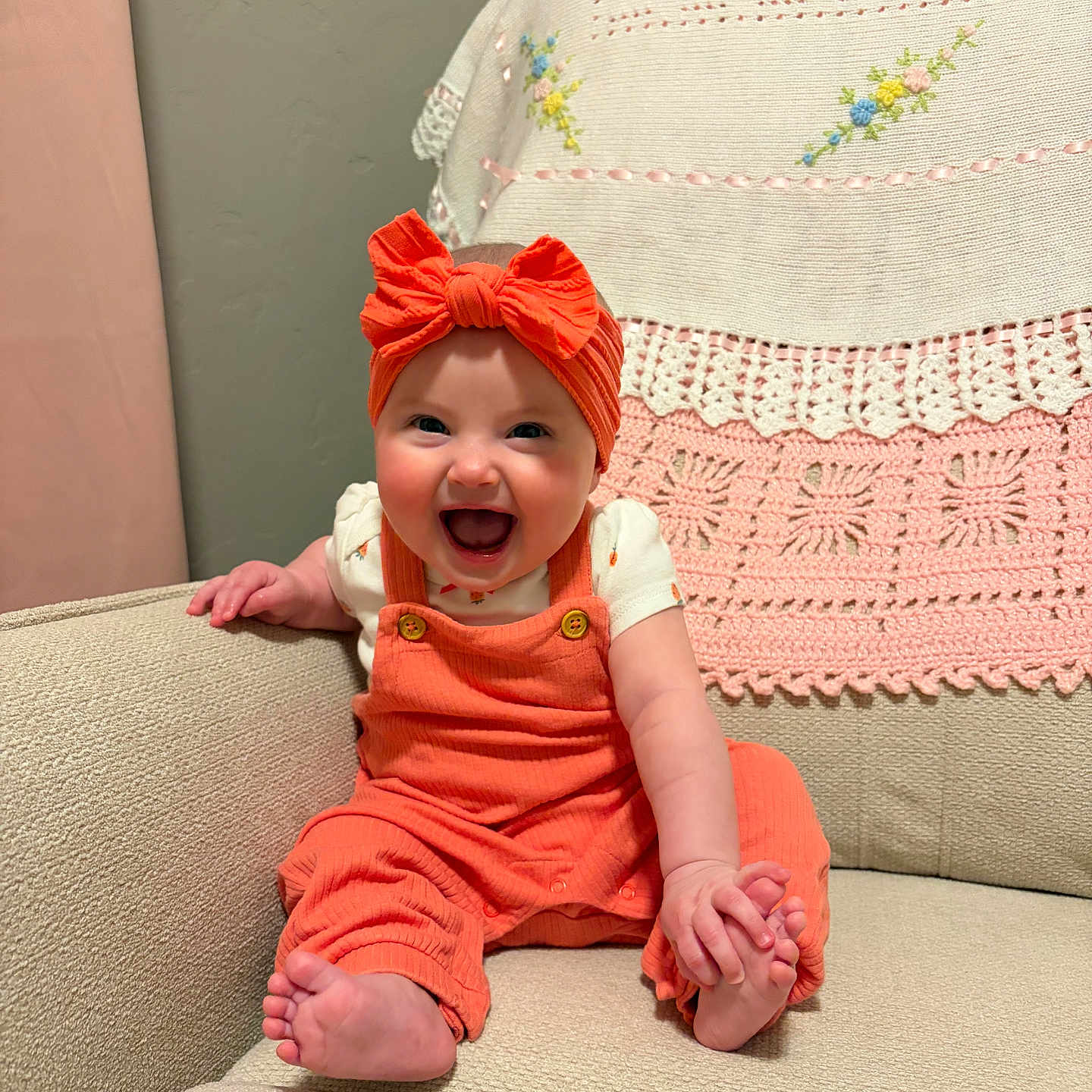 Magdalene joined the competition — help win amazing prizes! baby, child, smiling, orange_clothing, headband, couch, blanket, crochet, embroidery, happy, indoor, infant, sitting, cute, portrait, person, furniture, comfortable, bright, expression