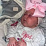 baby, sleeping, pink_bow, white_outfit, blanket, pacifier, hand, face, infant, cute, soft_texture, embroidery, peaceful, closeup, newborn, indoors, resting, child, headwear, cozy