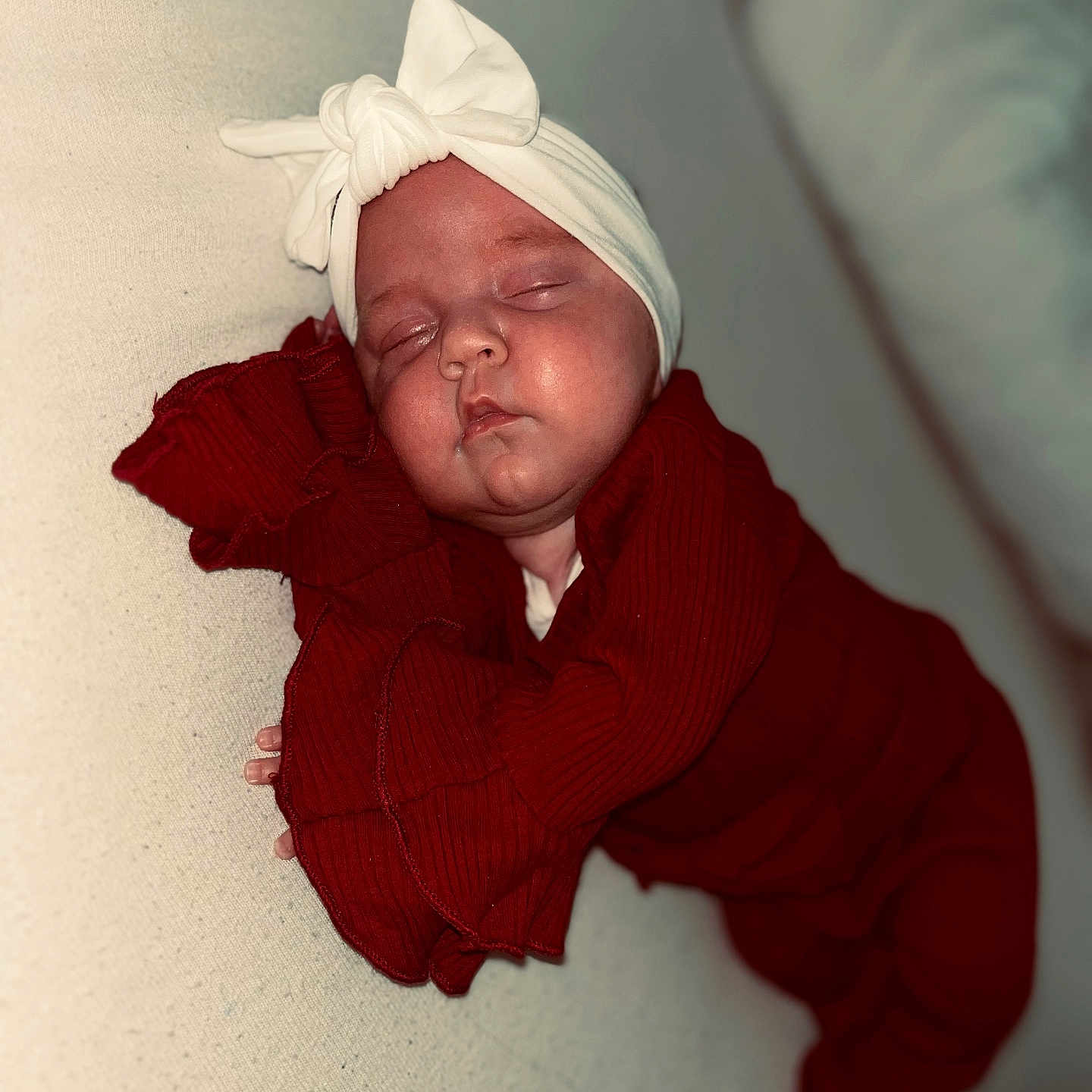 Djyseï participe au concours pour gagner de l'argent avec cette photo : baby, blanket, bow, child, closeup, cozy, cute, face, hand, headband, indoors, infant, peaceful, portrait, red_outfit, resting, skin, sleeping, soft_lighting, toddler