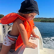 Heaven participe au concours pour gagner de l'argent avec cette photo : adventure, blue_sky, boat, child, clothing, curious, daylight, hat, life_jacket, nature, outdoor, person, river, side_view, sitting, summer, sunny, toddler, water, watercraft