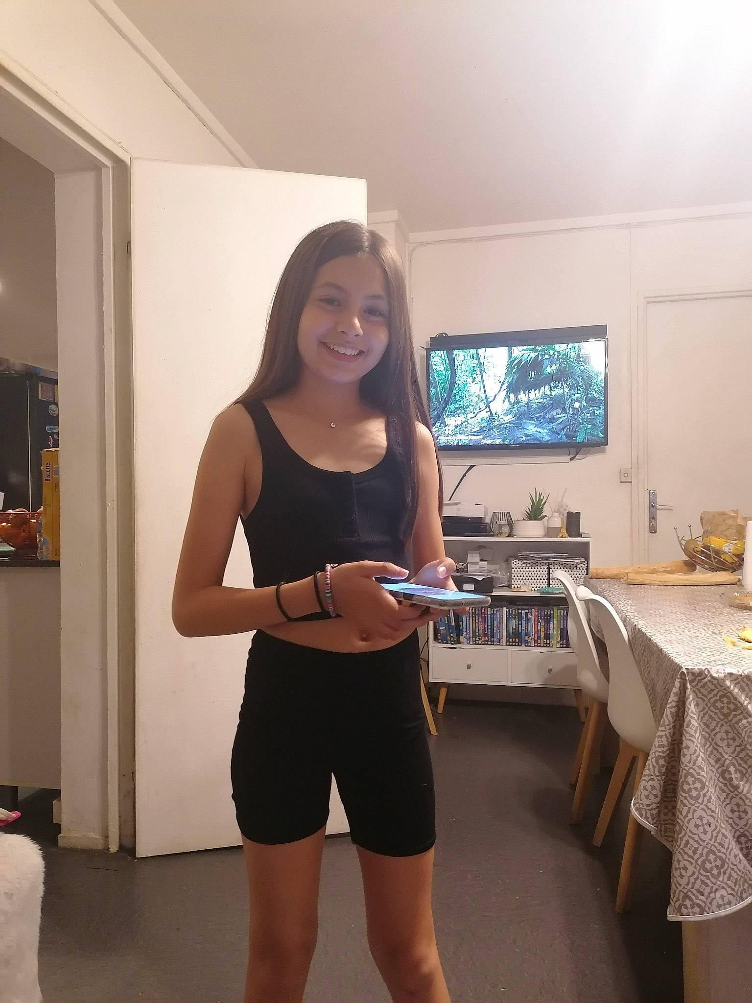 Eva participe au concours pour gagner de l'argent avec cette photo : chest, elbow, event, eyewear, floor, flooring, human_leg, joy, knee, leg, long_hair, person, picture_frame, shorts, shoulder, smile, sportswear, t_shirt, table, thigh