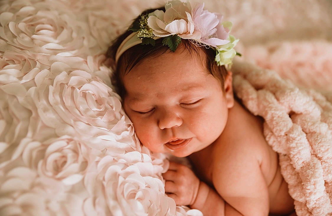 Macey is registered to the contest to win money with this photo: baby, baby_sleeping, baby_toddler_clothing, child, comfort, finger, flash_photography, flower, happy, headband, headpiece, iris, jewellery, peach, person, petal, pink, skin, sweetness, textile