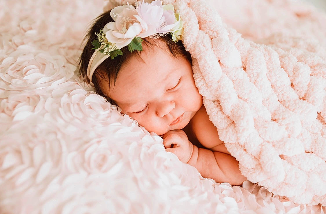 Macey is registered to the contest to win money with this photo: baby, baby_sleeping, baby_toddler_clothing, comfort, event, finger, flash_photography, flower, grass, hand, happy, headband, headgear, headpiece, iris, linens, person, petal, pink, skin