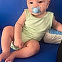 Alessio participe au concours pour gagner de l'argent avec cette photo : baby, infant, pacifier, blue_couch, green_clothing, diapers, sitting, cute, child, indoor, plump, skin, person, furniture, relaxed, chubby_arms, legs, head, expression, comfort