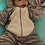 baby, child, infant, onesie, tiger_stripes, hood, ears, cushion, soft, cozy, hand, curious, lying_down, cute, clothing, warm, indoor, portrait, expression, comfortable