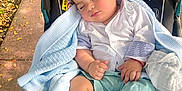 Valentino joined the competition — help win amazing prizes! baby, sleeping, stroller, blanket, outdoor, sidewalk, leaf, child, clothing, foot, hand, person, rest, cute, peaceful, summer_clothing, infant, toddler, nature, relaxation