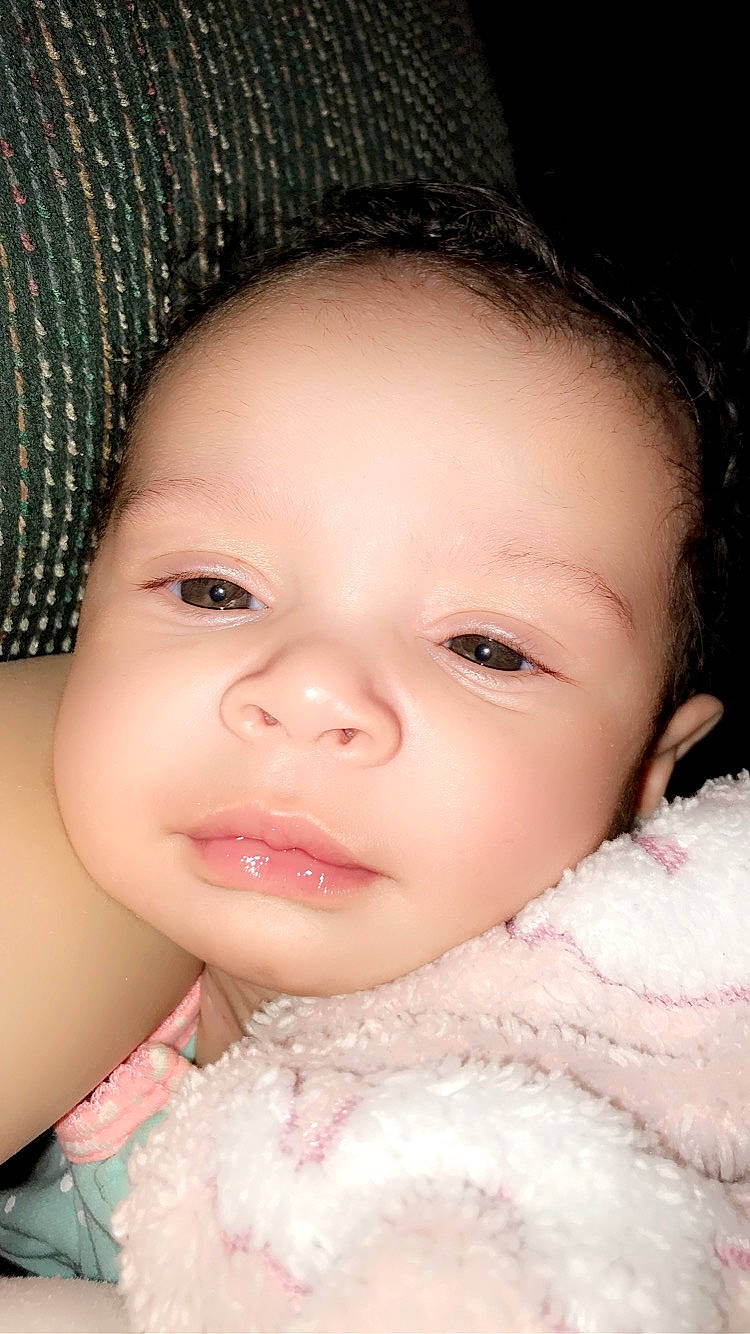 Rosemarie is registered to the contest to win money with this photo: baby, baby_toddler_clothing, cheek, chin, eye, eyebrow, eyelash, face, forehead, hairstyle, iris, lip, mouth, neck, nose, organ, person, photograph, skin, textile