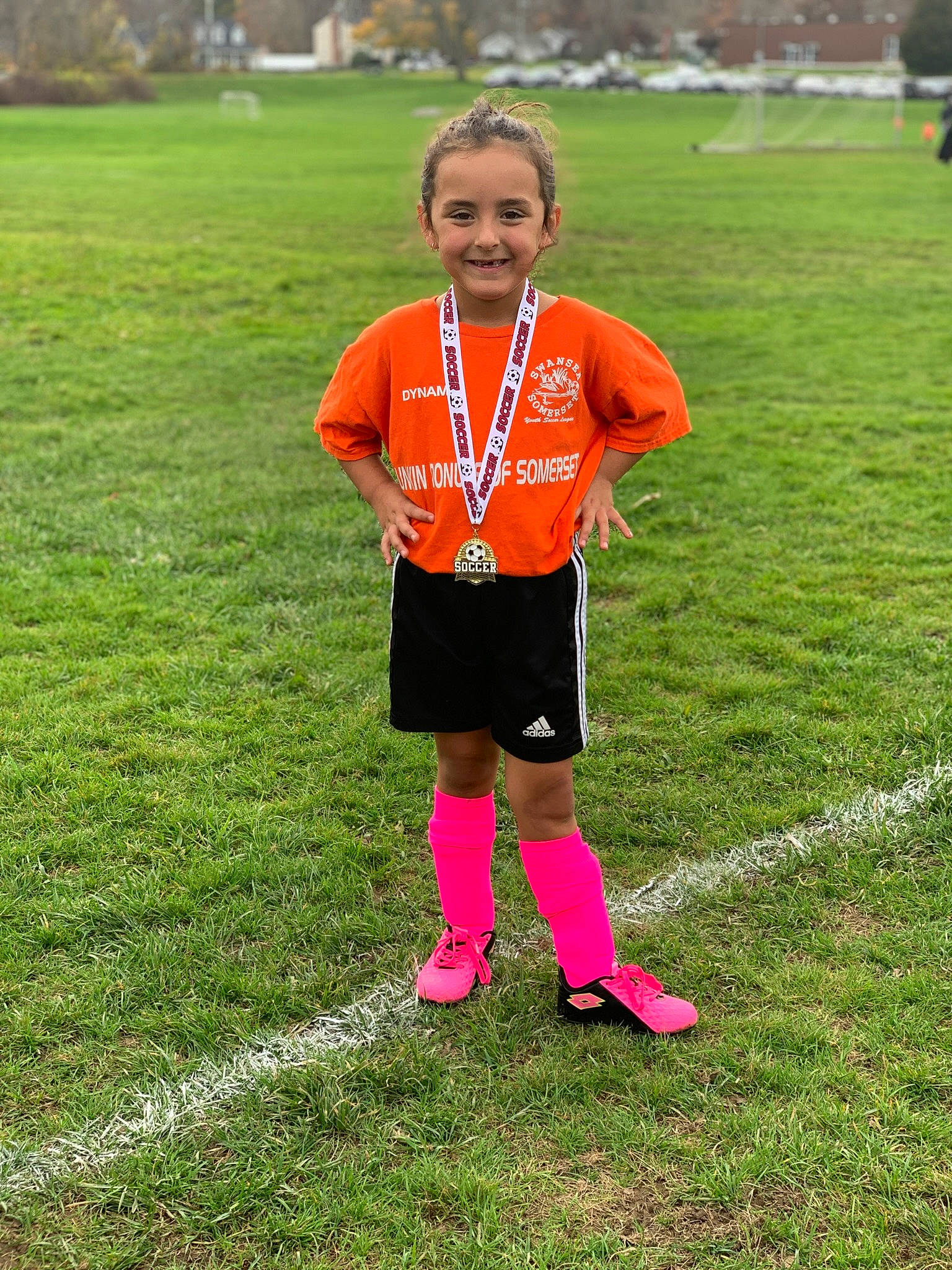 Lexi is registered to the contest to win money with this photo: athlete, competition_event, grass, grassland, happy, joy, leisure, people_in_nature, person, player, recreation, running, shorts, smile, sneakers, soccer_ball, sock, sports, sports_equipment, sportswear