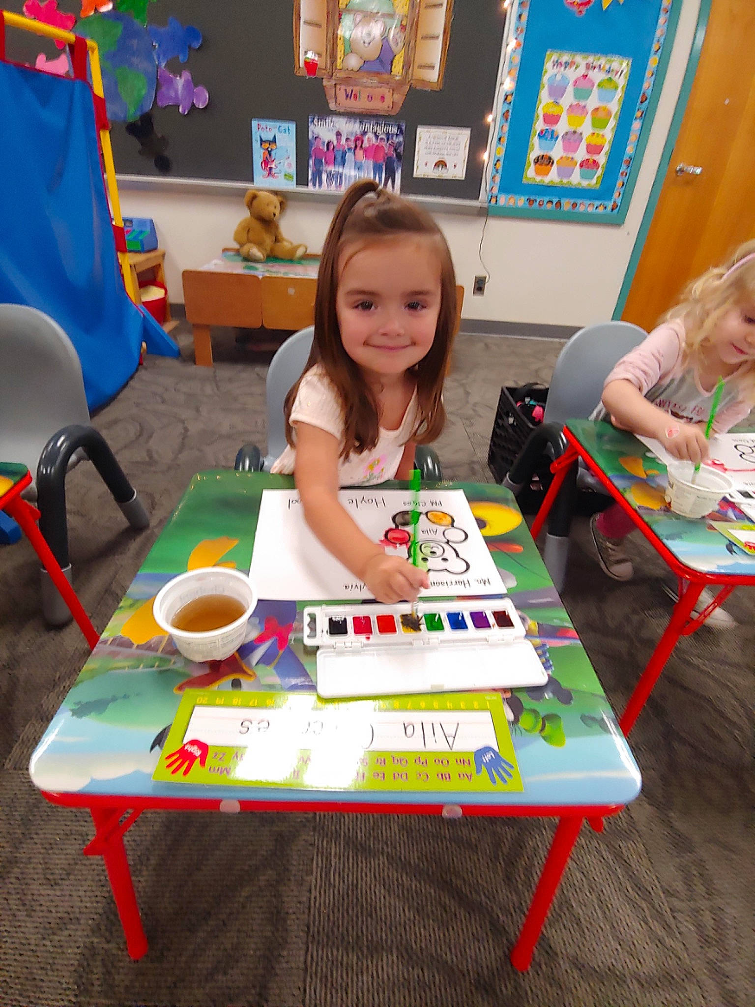 Aila joined the competition — help win amazing prizes! academic_institution, chair, child, desk, education, event, fun, furniture, joy, kindergarten, learning, leisure, person, picture_frame, play, sharing, smile, summer, t_shirt, table