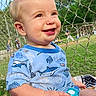 Ronin is registered to the contest to win money with this photo: baby, child, blue_clothing, toy, smiling, outdoor, grass, fence, baseball, sport, person, happy, play, daylight, nature, cute, infant, portrait, field, summer