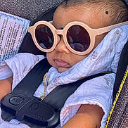 Ayush joined the competition — help win amazing prizes! baby, car_seat, sunglasses, child, infant, seatbelt, blanket, clothing, gold_chain, fashion, portrait, cute, accessory, white, black_straps, head, face, skin, relaxing, babywearing