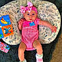 baby, baby_girl, blue_eyes, carpet, child, colorful, cushion, cute, headband, indoor, infant, leaf_pattern, onesie, phone_case, pink_bow, portrait, relaxing, sneakers, soft_fabric, toy