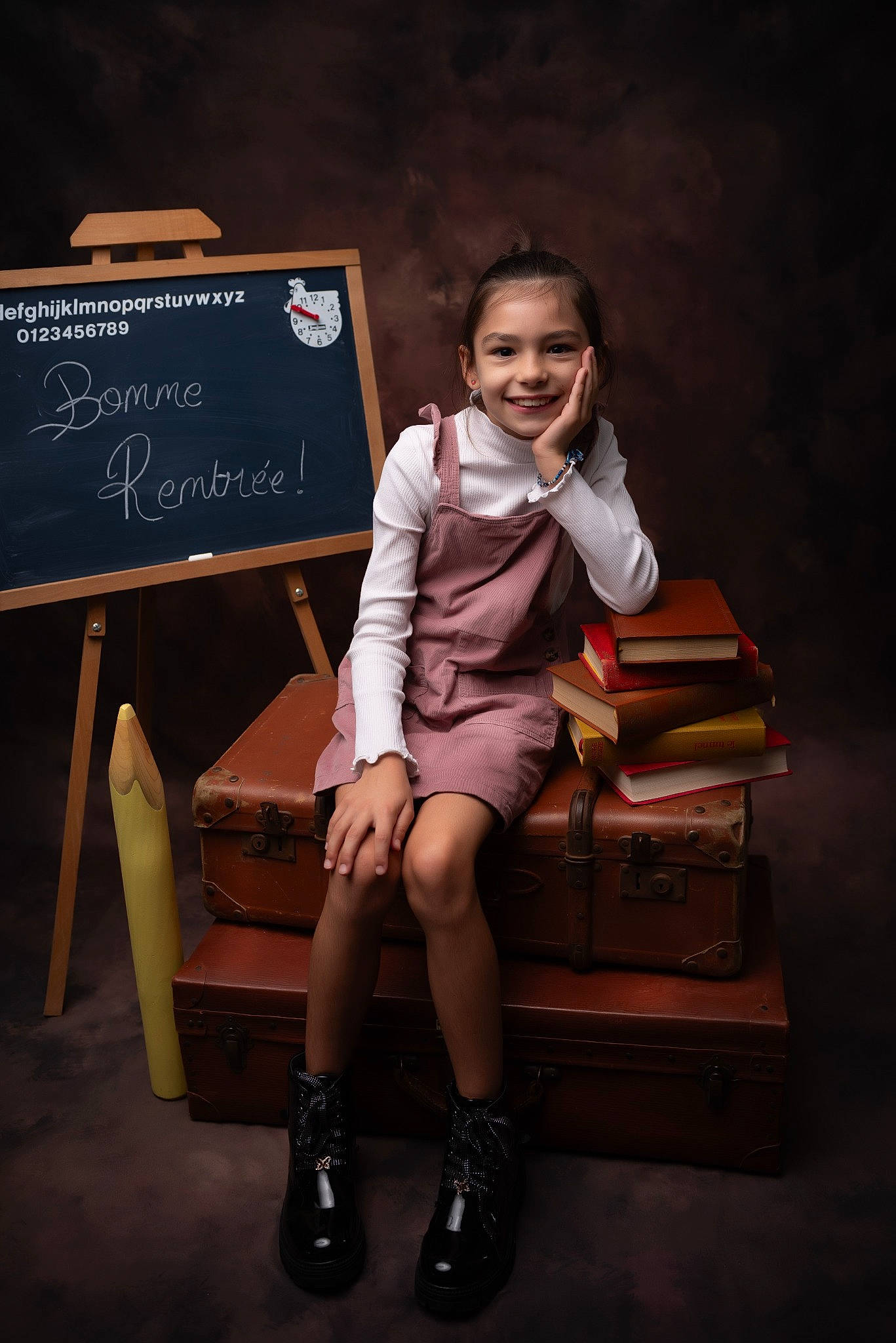 Julianne participe au concours pour gagner de l'argent avec cette photo : bag, boot, brown_hair, chair, darkness, fashion_design, flash_photography, formal_wear, fun, happy, human_leg, joy, knee, luggage_and_bags, person, room, sitting, smile, standing, thigh