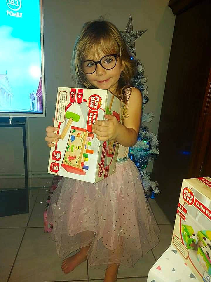 Laora participe au concours pour gagner de l'argent avec cette photo : blond, brown_hair, day_dress, display_device, dress, fictional_character, one_piece_garment, opening_presents, packaging_and_labeling, pattern, person, present