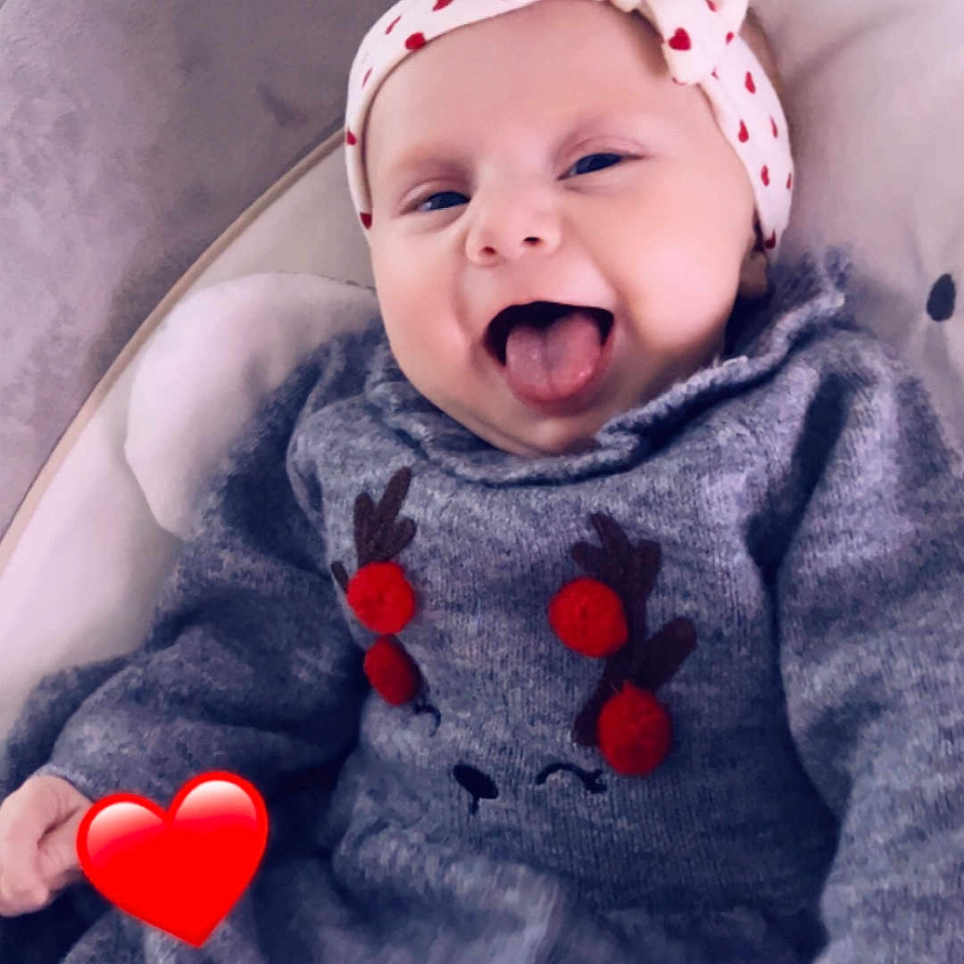 Emilia participe au concours pour gagner de l'argent avec cette photo : baby, child, close_up, cozy, cushion, cute, happy, headband, hearts, indoor, infant, person, playful, pom_poms, reindeer, seat, smiling, sweater, tongue_out, warm_clothing