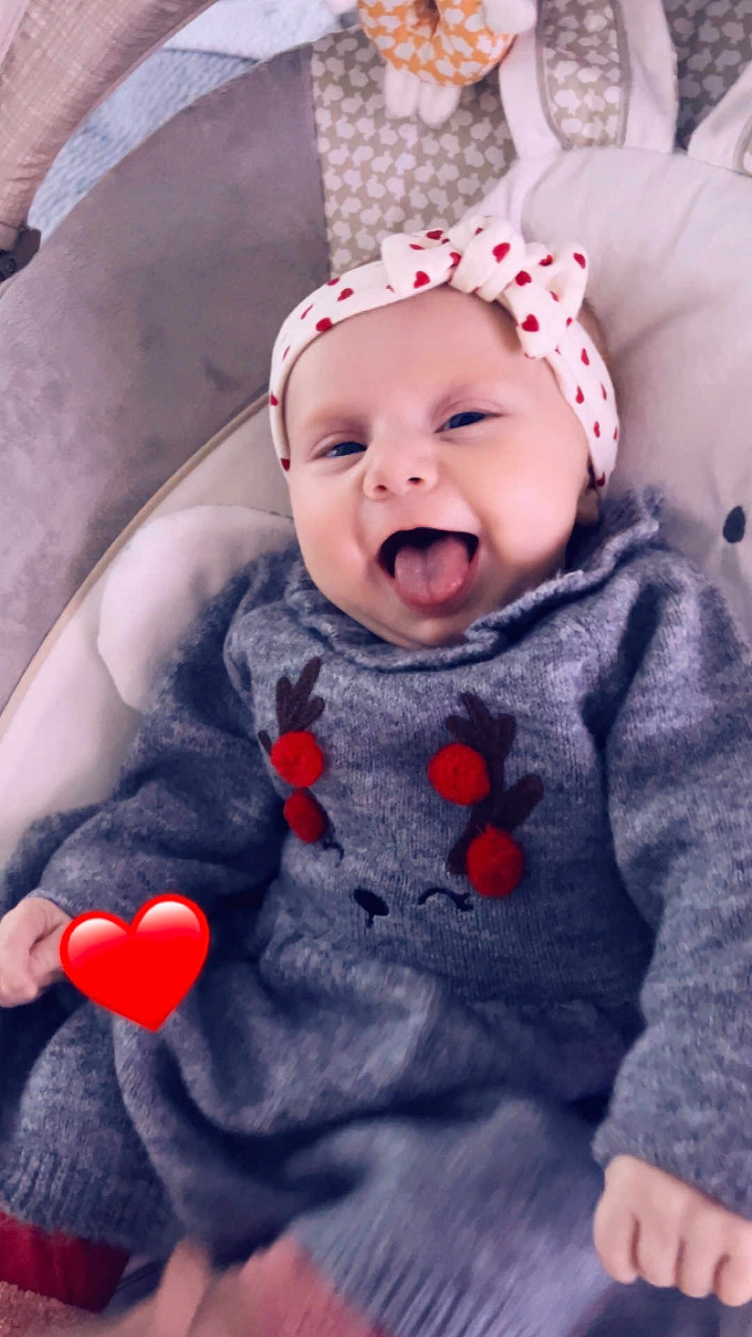 Emilia participe au concours pour gagner de l'argent avec cette photo : baby, child, infant, smiling, tongue_out, headband, hearts, sweater, reindeer, pom_poms, cute, cushion, seat, happy, playful, indoor, close_up, cozy, warm_clothing, person