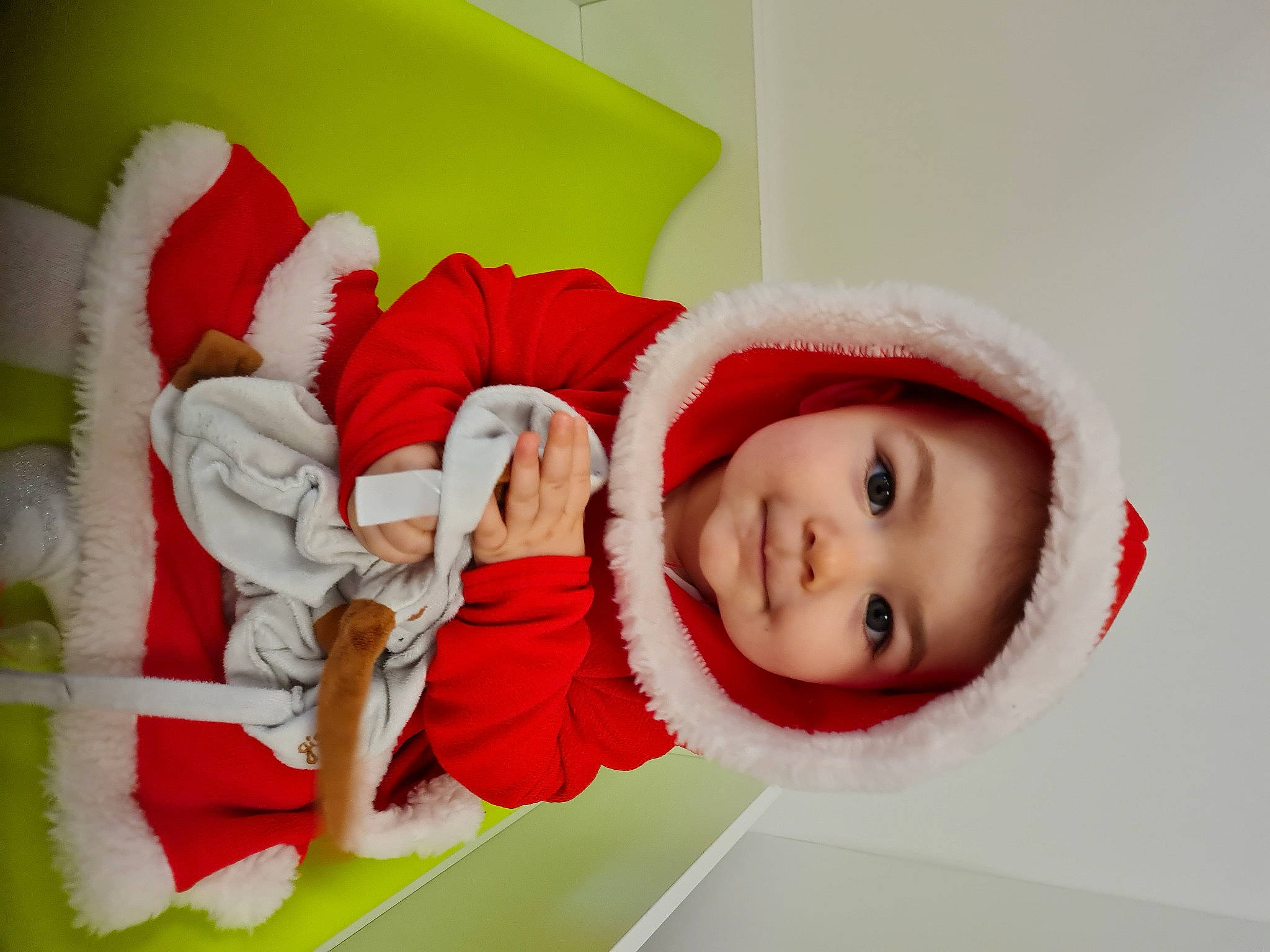 Mathilda participe au concours pour gagner de l'argent avec cette photo : baby, baby_toddler_clothing, carmine, child, christmas, christmas_eve, comfort, costume_accessory, costume_hat, fictional_character, fur, fur_clothing, headwear, holiday, hood, human, person, pleased, red, santa_claus