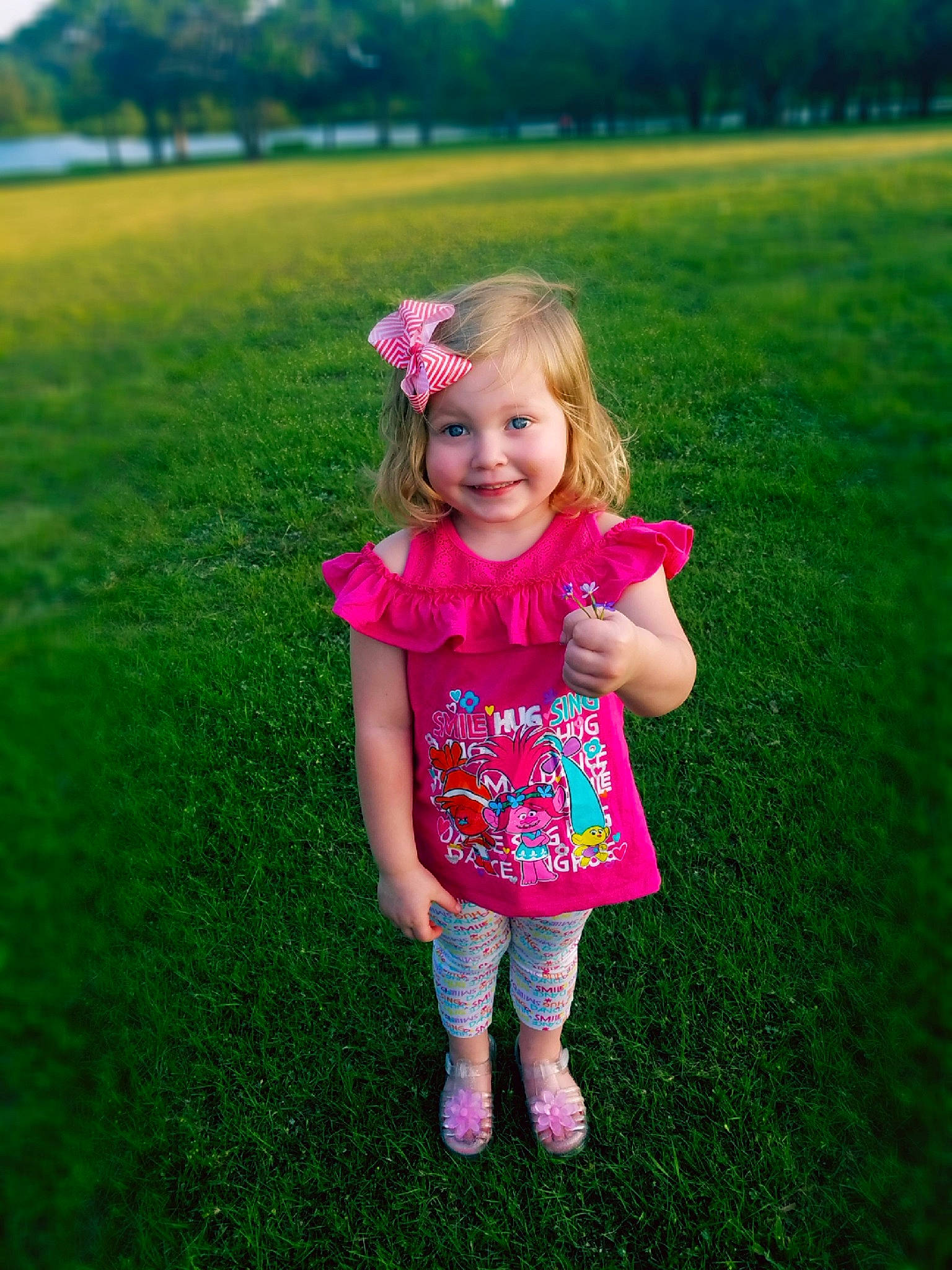 Larissa is registered to the contest to win money with this photo: child, clothing, day, emotion, facial_expression, fun, girl, grass, green, joy, lawn, meadow, person, pink, plant, play, purple, smile, spring, standing