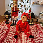 Maloë participe au concours pour gagner de l'argent avec cette photo : baby, red_clothing, headband, smiling, christmas_tree, nutcracker, ornaments, blanket, holiday, indoor, decorations, floor, lamp, wooden_floor, festive, toy, face, person, child, happy