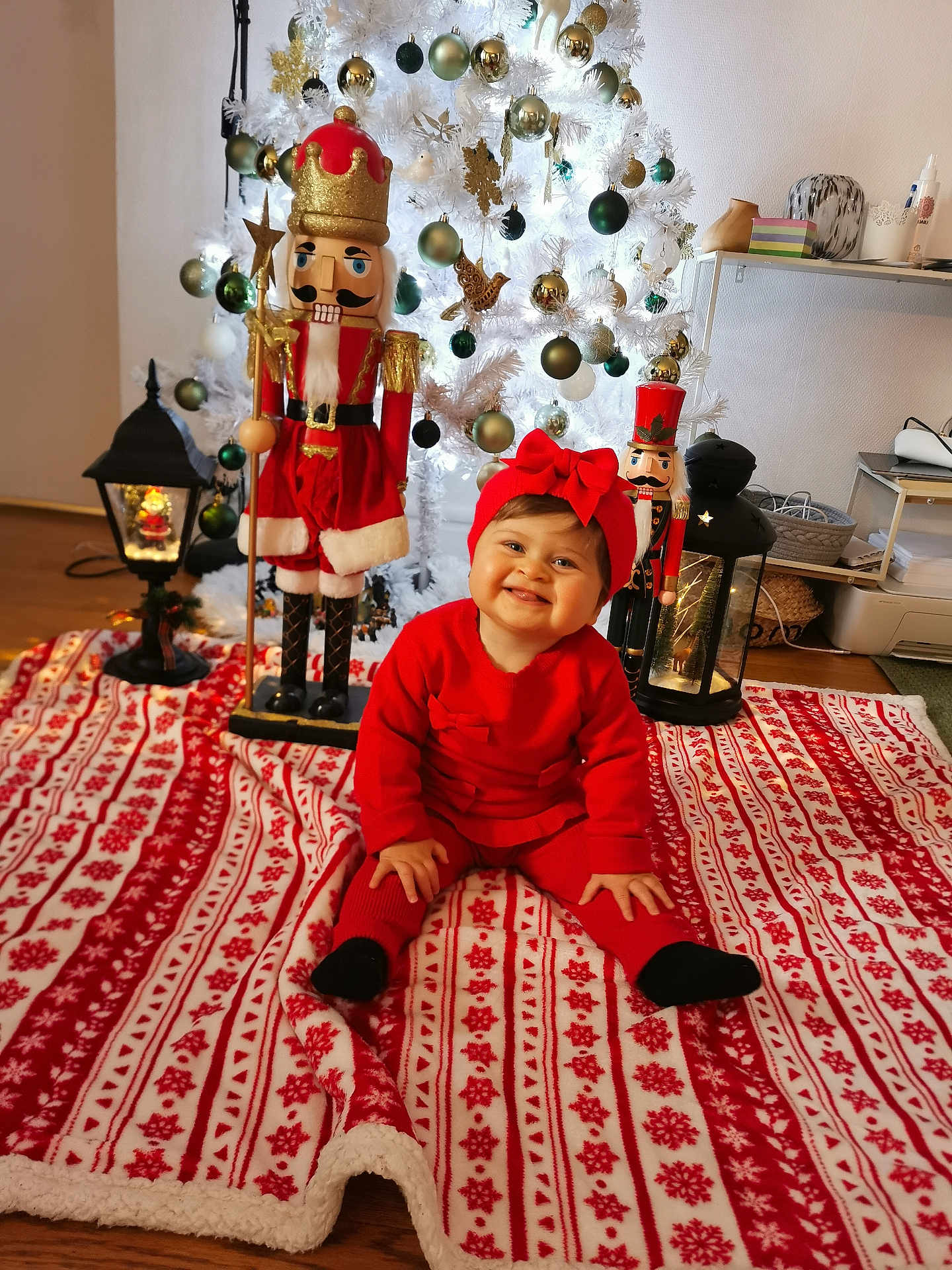Maloë participe au concours pour gagner de l'argent avec cette photo : baby, red_clothing, headband, smiling, christmas_tree, nutcracker, ornaments, blanket, holiday, indoor, decorations, floor, lamp, wooden_floor, festive, toy, face, person, child, happy